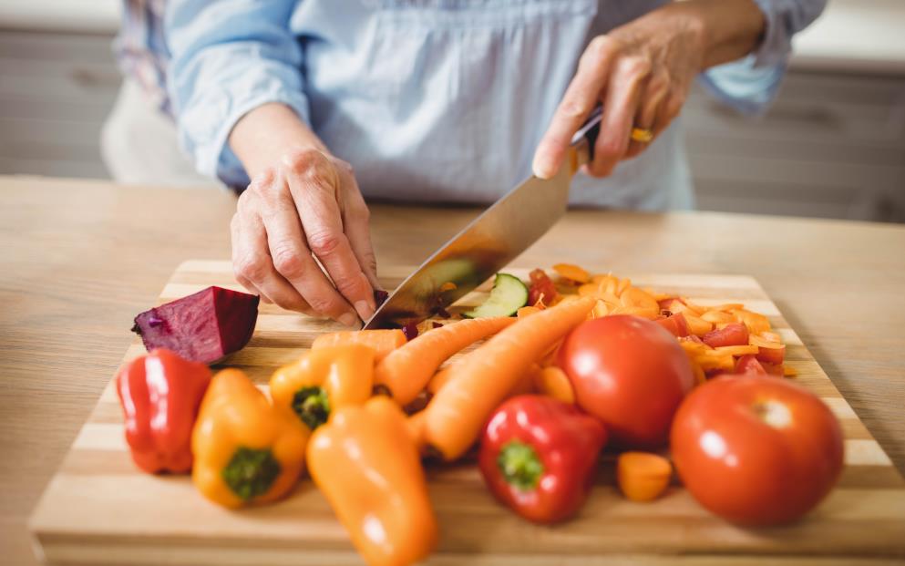 Chef cutting vegetables using a steel made handle