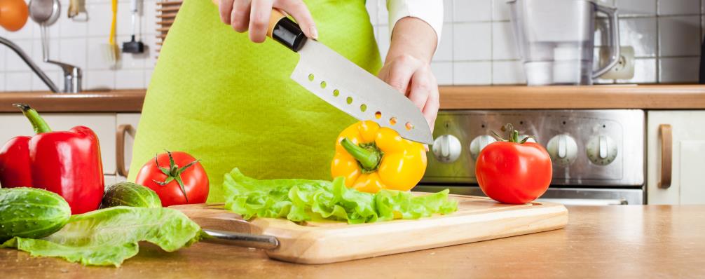 Woman cutting vegetable using stamped knife