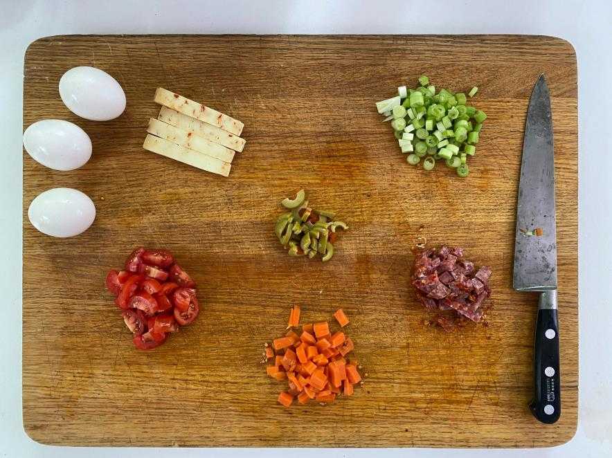 Cutting board with cut vegetables and eggs