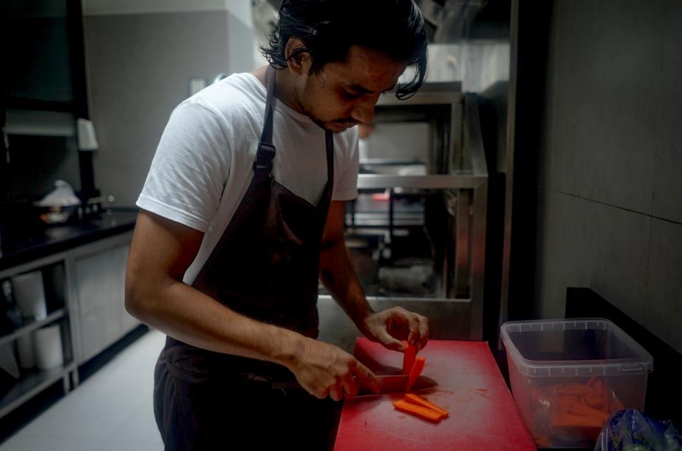 chef cutting carrots on rubber cutting board