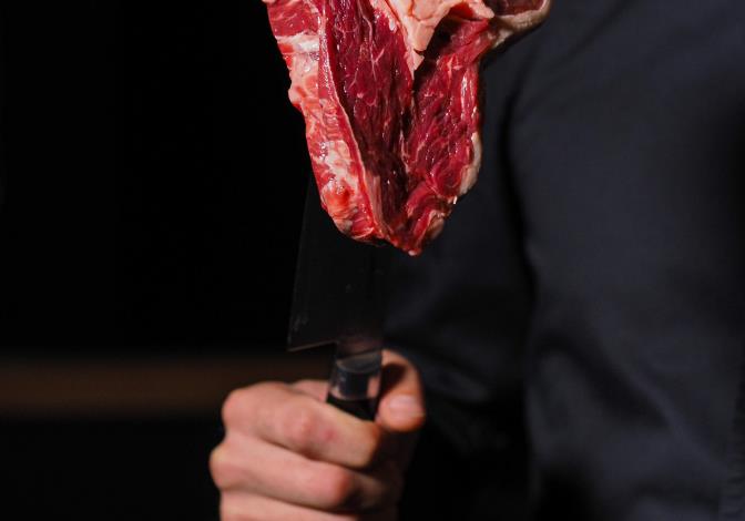 Chef using a chukabocho to hold a piece of meat