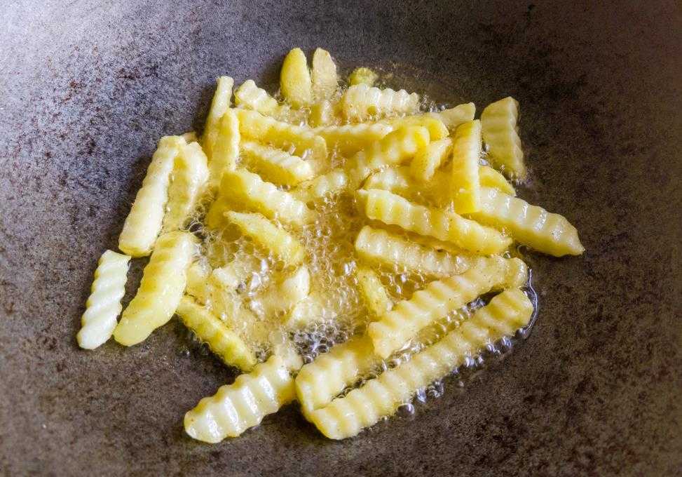 fries cooking inside cast iron pan