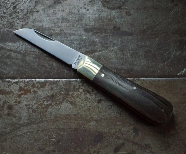 Michael May Bog Oak Lambfoot pocket knife open on a metal work surface