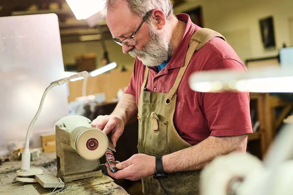 A Savernake craftsperson polishing a patterned knife handle
